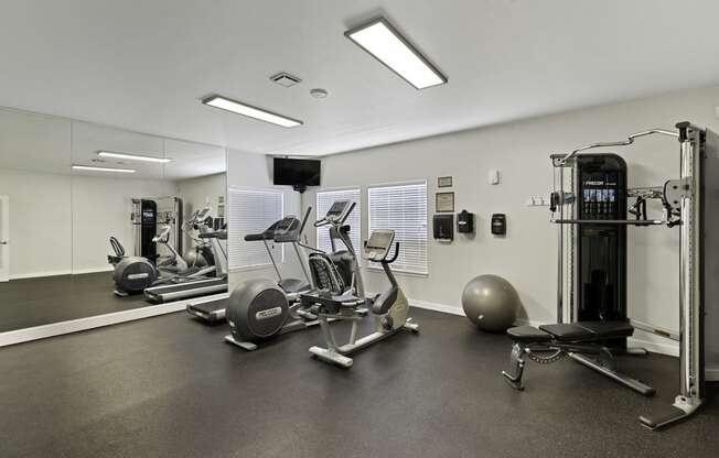 a gym with cardio equipment and weights at Serra Vista Apartment Homes, Lynnwood