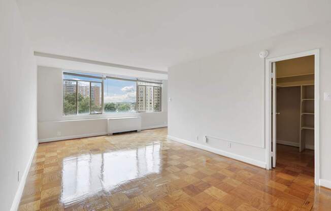 A room with a checkered floor and a window overlooking a cityscape.