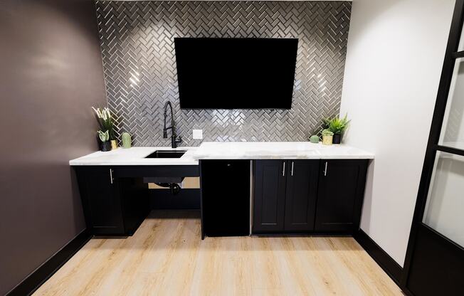 a black and white bathroom with a sink and a tv