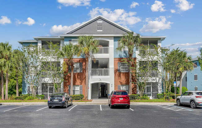 A multi-story apartment building with a parking lot in front at Wynnfield Lakes Apartments in Jacksonville, FL