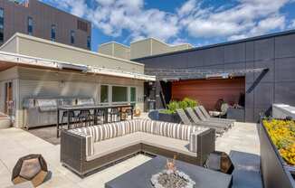 a patio with couches and tables and a fire pit