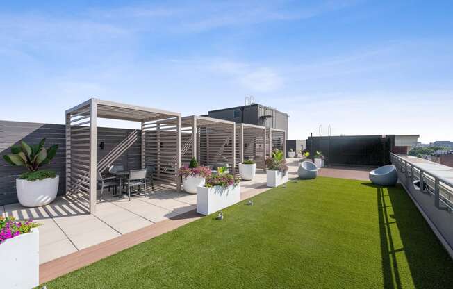 a roof top terrace with a lawn and potted plants