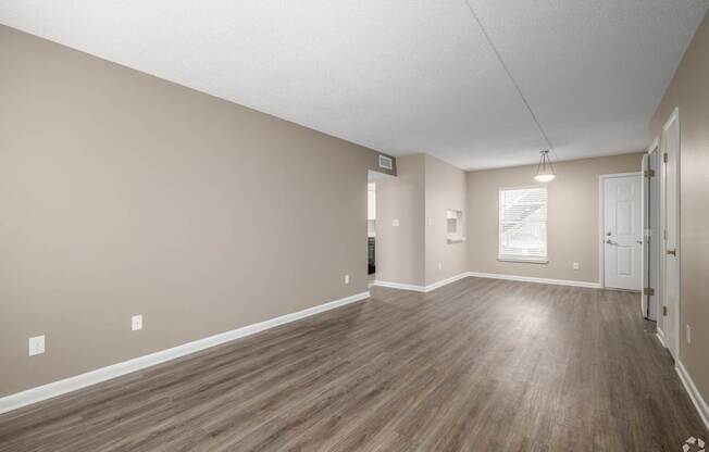 A room with wooden flooring and white walls.