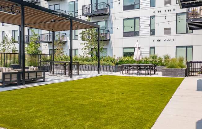 an outdoor lounge area with tables and chairs on a sunny day