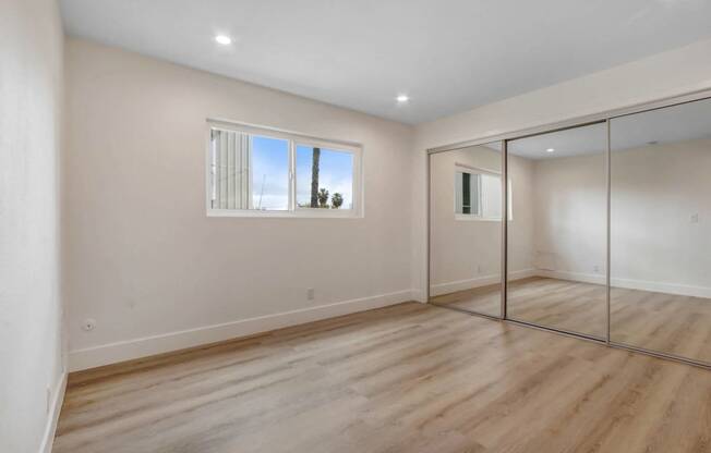 a living room with white walls and sliding glass doors and a window