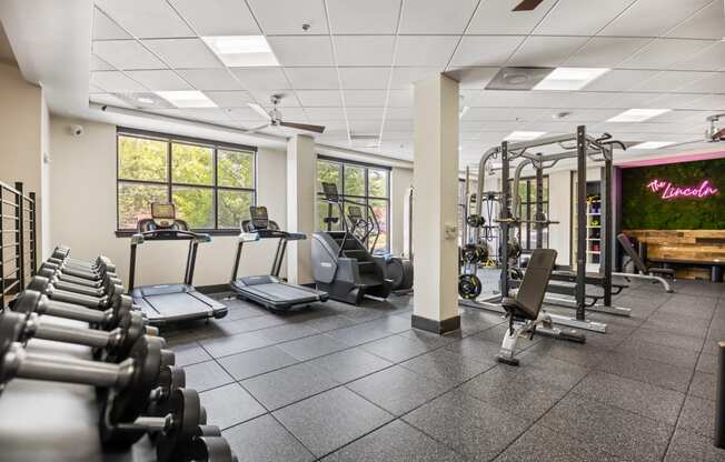 a gym with treadmills and other exercise equipment and windows