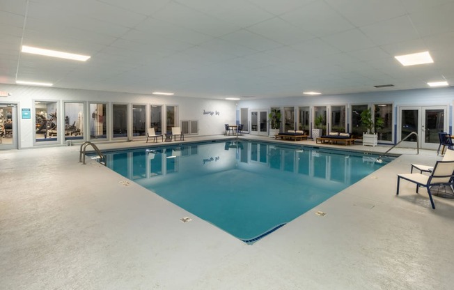 a large indoor swimming pool with lounge chairs and tables