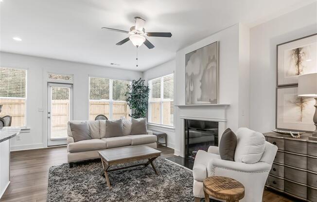 a living room with a couch and a chair and a ceiling fan