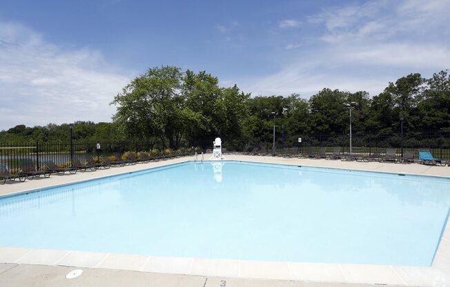 a large swimming pool with trees in the background