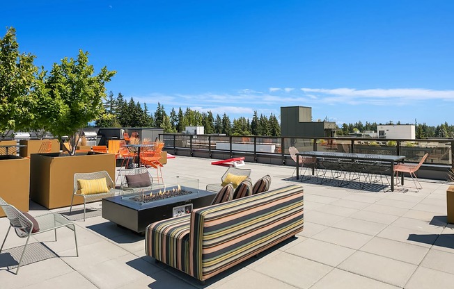A patio with a striped couch and chairs.