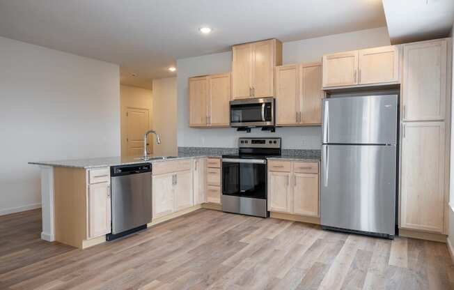 an empty kitchen with wooden cabinets and stainless steel appliances