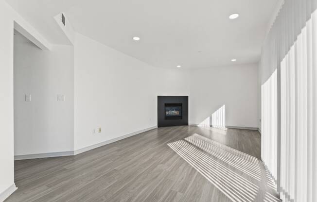 a living room with white walls and a black fireplace