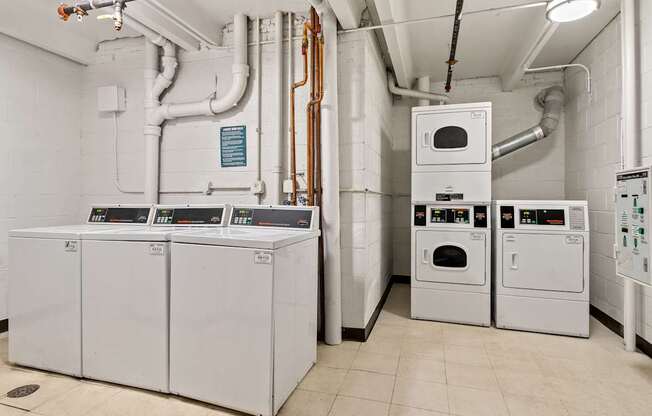 A series of industrial ovens and pipes in a clean, white room.