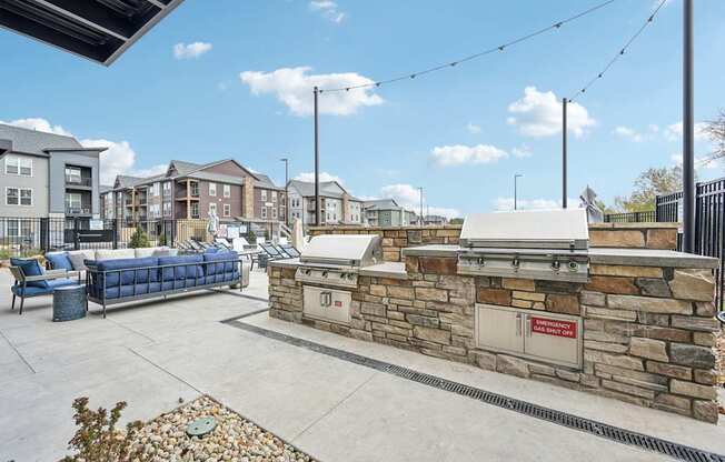 the clubhouse has an outdoor patio with a grill and a seating area at The Quarry Luxury Apartment Homes, Fort Collins