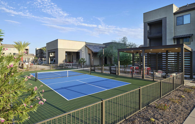 a tennis court is in the middle of a house with a fence