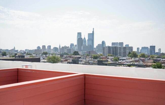 the view of the city from the rooftop terrace of a building with a bench