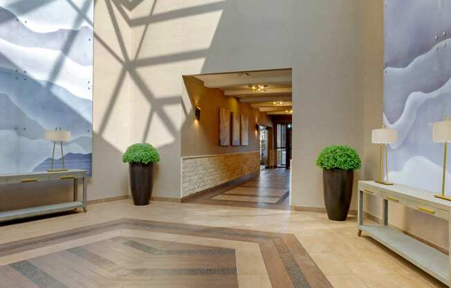 the lobby of a hotel with a view of a hallway with plants at The Rays at Vegas Towers Apartments, Nevada