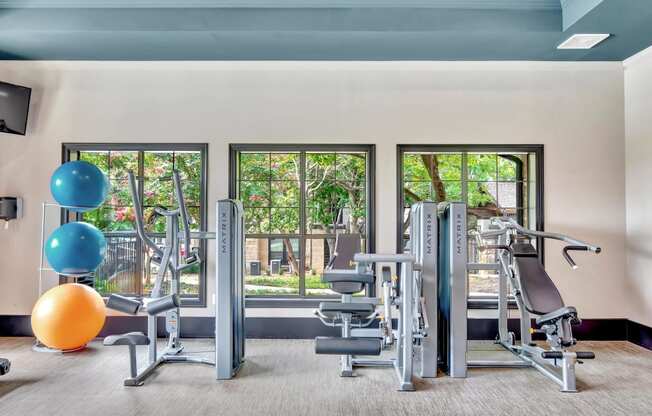 a gym with exercise equipment and large windows