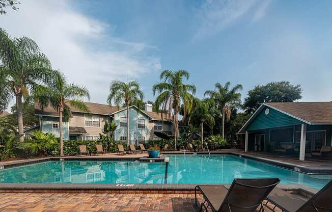 a swimming pool with palm trees in front of a house