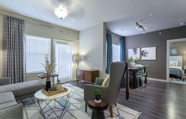 A living room with a grey couch, a white coffee table, and a grey armchair.