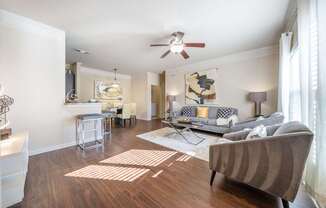 A living room with a grey couch and a wooden floor.