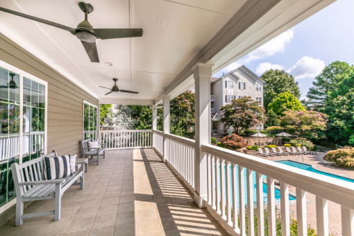 the back porch of a house with a pool and a porch swing