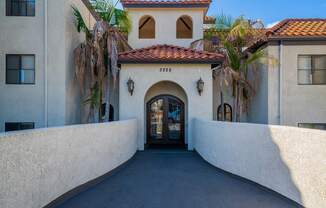 the front door of a building with palm trees