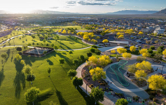an aerial view of a park with the city in the background