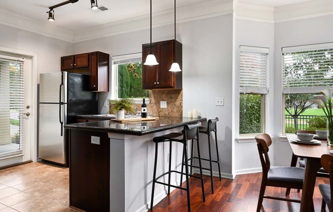 a kitchen with a bar and a table with stools at Sovereign at Overland Park, Overland Park, KS 66213  