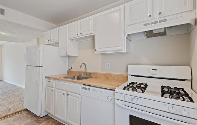 Kitchen with white cabinets and white appliances at Barracks West apartments in Charlottesville, VA