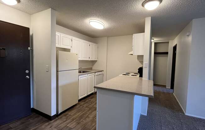 a kitchen with white cabinets and white appliances