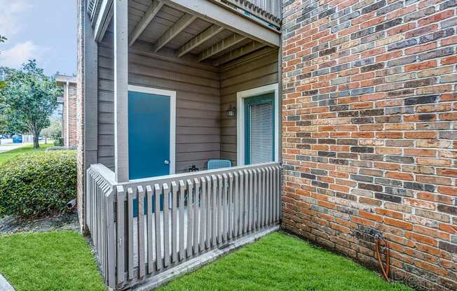 our apartments have a balcony with a brick wall and a white fence