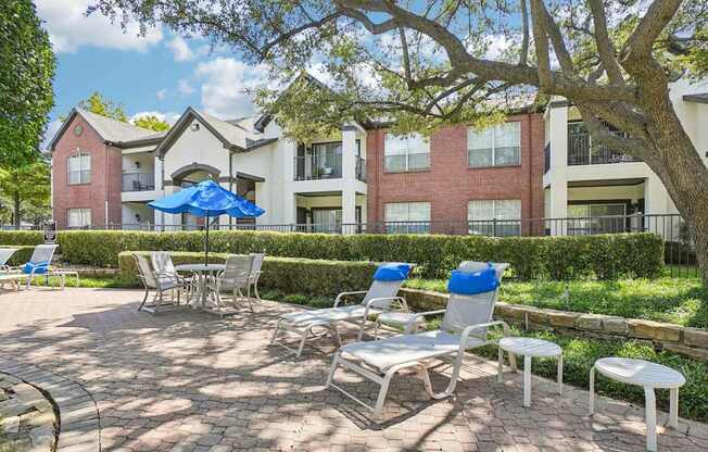 A patio with chairs and a table in front of a building.