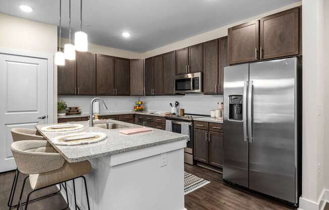 A modern kitchen with a granite countertop and stainless steel appliances.