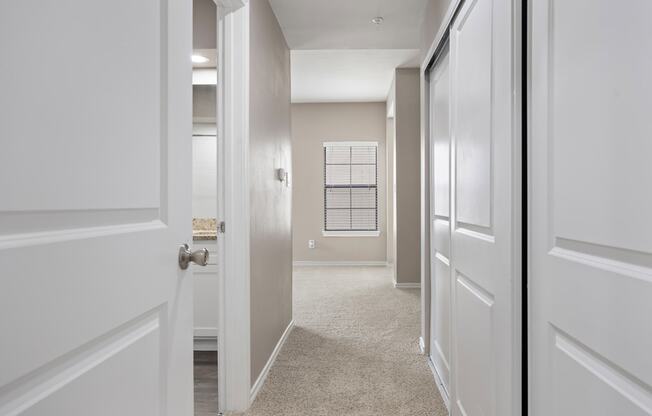 a hallway with two doors and a window in the background