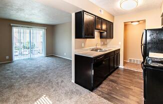 a kitchen and living room with a sliding glass door