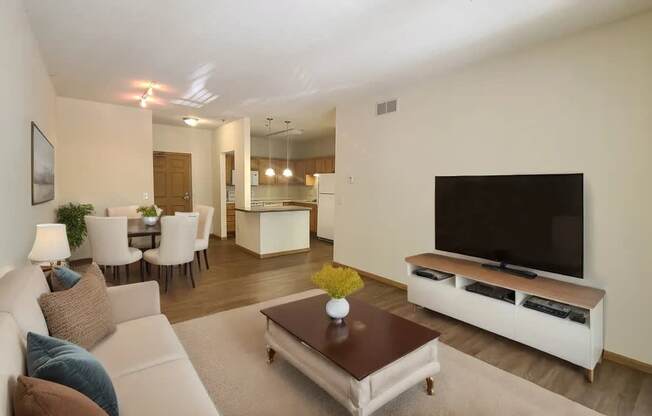 A living room with a white couch, a brown coffee table, and a flat screen TV.