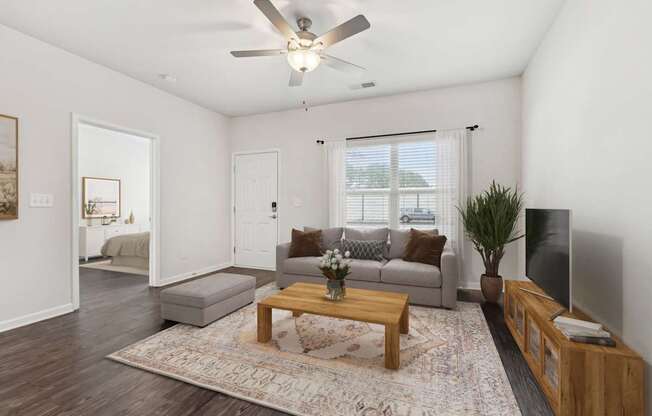 A living room with a grey couch, a wooden coffee table, and a flat screen TV.