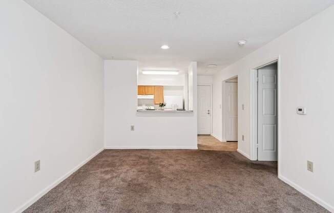 A large, empty room with a carpeted floor and white walls.