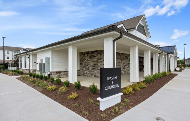 Dog-Friendly Apartments in Gallatin, TN - Banner at Westfield - Exterior View of Leasing Office and Clubhouse with Concrete Pathway and Maintained Landscaping.