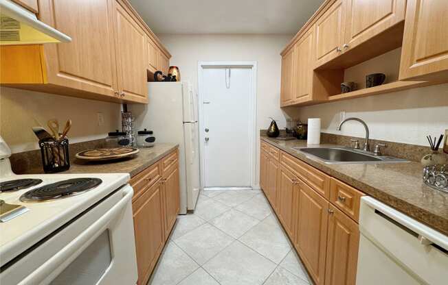 a kitchen with white appliances and wooden cabinets