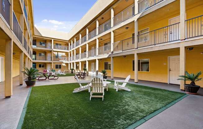 a courtyard with a lawn and chairs and tables at Dronfield Astoria, California, 91342