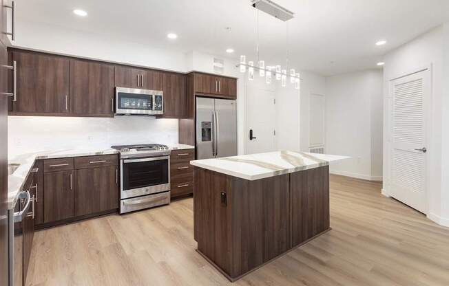 A modern kitchen with wooden cabinets and stainless steel appliances. at Elements Apartments*, Irvine, CA, 92612