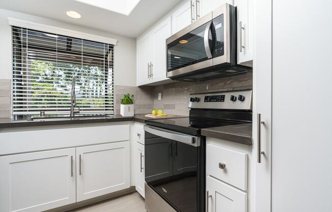 Kitchen with bay window, stove and microwave