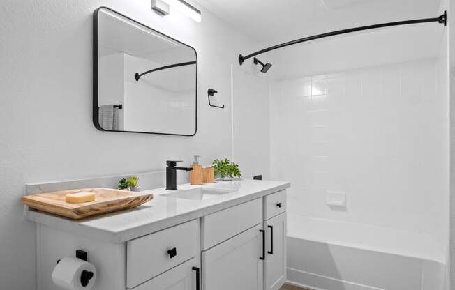 a white bathroom with a sink and a mirror