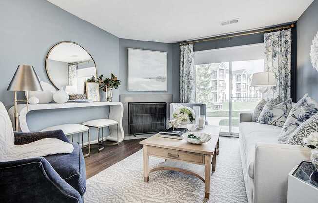 A living room with a grey couch, a wooden coffee table, and a fireplace.