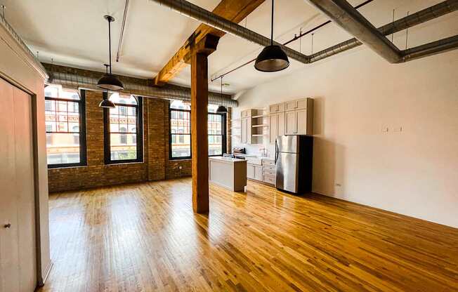A large empty room with wooden floors and exposed ceiling beams.