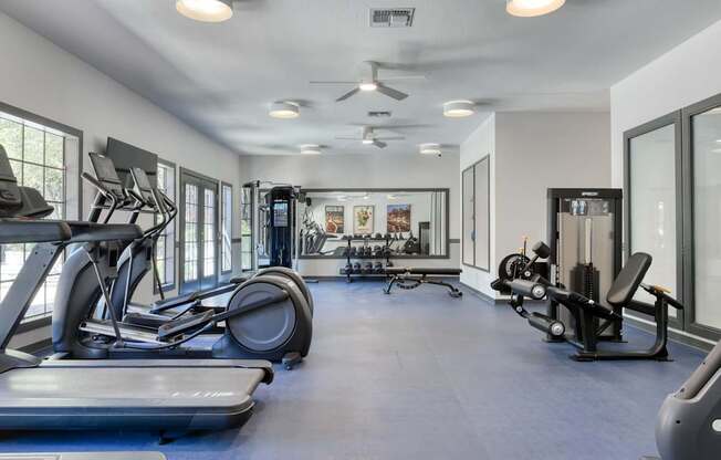 A spacious gym with a variety of equipment including treadmills, weights, and exercise machines.