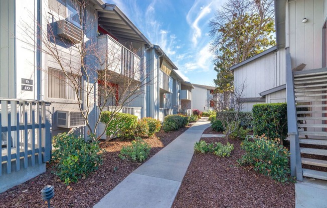 a walkway between two buildings with a blue sky in the background at Sunnyvale Crossings Apartments, LLC, Sunnyvale California