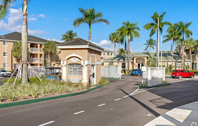 A street view of a residential area with palm trees and houses.